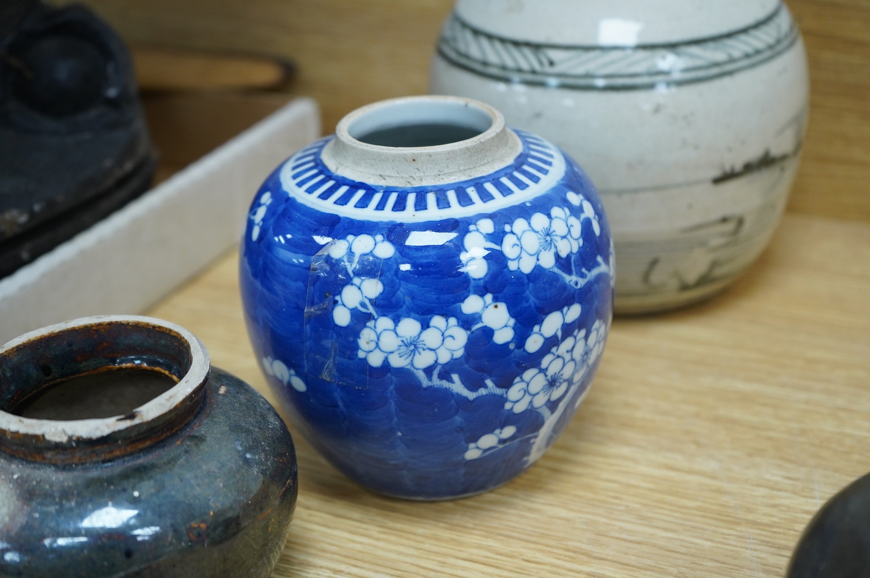 A collection of Chinese pottery jars and a decorated plate, tallest jar 18cm high